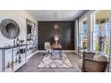 Inviting home office with a stylish accent wall, modern desk, comfortable seating, and natural light at 19738 Gladeview Way, Land O Lakes, FL 34638