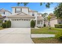Inviting two-story home featuring a two-car garage, manicured lawn and front garden at 20123 Bay Cedar Ave, Tampa, FL 33647