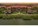 Beautiful waterfront condo building with well-manicured landscaping and lush tropical greenery at 2746 Via Tivoli # 135A, Clearwater, FL 33764