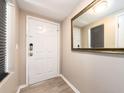 Modern entryway with a front door, wood-look flooring, and a large mirror enhancing the sense of space at 320 Island Way # 606, Clearwater Beach, FL 33767