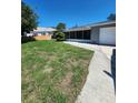 A lovely view of the front yard showing the house, lawn, and driveway at 4753 48Th N Ave, St Petersburg, FL 33714