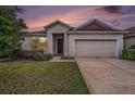 Charming single-story home featuring a well-manicured lawn, neutral paint, and an attached two-car garage at 672 Old Windsor Way, Spring Hill, FL 34609