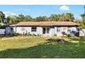 Inviting single-story home with a well-maintained front lawn, manicured landscaping, and distinctive sun decoration at 6907 W Creek Dr, Tampa, FL 33615