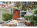 Close up of the front entrance with red double doors, beautiful landscaping, and a brick pathway at 915 Live Oak Ne Ter, St Petersburg, FL 33703