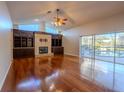 Cozy living room featuring hardwood floors, fireplace with built-in cabinetry, and sliding door access to a screened-in pool at 9159 Highland Ridge Way, Tampa, FL 33647
