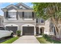Charming home with gray exterior, dark shutters, two-car garage, and a manicured lawn at 10212 Westpark Preserve Blvd, Tampa, FL 33625