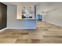 Spacious area featuring wood-look floors, modern lighting, and an open view to the kitchen at 1361 Overlea St, Clearwater, FL 33755