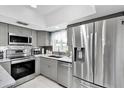 Well-lit kitchen with stainless steel appliances and gray cabinetry, perfect for modern living at 1428 Chesterfield Dr, Dunedin, FL 34698