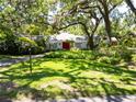 Beautifully landscaped front yard and mature trees highlight this white brick home at 1603 Cottagewood Dr, Brandon, FL 33510