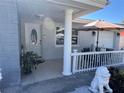 Inviting front porch featuring white railings, gray brick accent, seating, and a decorative lion statue at 1748 Ragland Ave, Clearwater, FL 33765
