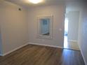 Living room with hardwood floors, a rectangular mirror, and white walls at 2001 World Parkway Blvd # 49, Clearwater, FL 33763