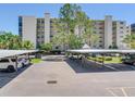 Wide shot showing the parking lot and multiple vehicles covered by awnings, with the building behind at 2700 Cove Cay Dr # 1-2D, Clearwater, FL 33760
