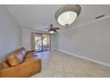 Spacious living room with tiled floors and sliding glass door to the balcony at 2739 Via Capri # 1024, Clearwater, FL 33764