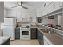 Well-lit kitchen with a ceiling fan, white appliances, and granite countertops at 3001 58Th S Ave # 509, St Petersburg, FL 33712