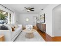 Cozy living room featuring neutral decor, a decorative fireplace, hardwood floors, and natural light at 432 39Th Ne Ave, St Petersburg, FL 33703