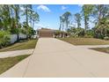 Wide driveway leading to a well-maintained single-story home, surrounded by lush trees and manicured lawn at 4344 Eldron Ave, North Port, FL 34286