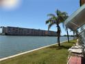 Lush lawn by the waterfront showing views of the condo buildings and palm trees on a sunny day at 5940 30Th S Ave # 206, Gulfport, FL 33707