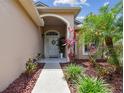 Inviting front entrance with a pathway, well-maintained plants and double doors at 6006 Chellas Ct, Lutz, FL 33558