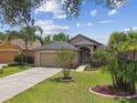 Charming single-story home with a well-manicured lawn and lush landscaping and two-car garage at 6006 Chellas Ct, Lutz, FL 33558
