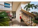 Exterior shot of condo building entrance, with stairs, tropical foliage, and a view of a palm tree at 6265 Sun Blvd # 115, St Petersburg, FL 33715