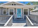 Close-up of the inviting front porch with a light blue door and decorative wreath at 6939 3Rd N St, St Petersburg, FL 33702