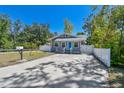 A single-Gathering home with a wide driveway and white picket fence in a sunny neighborhood at 6939 3Rd N St, St Petersburg, FL 33702
