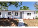 Inviting single-story home with a white brick exterior, gray accents and refreshed landscaping at 704 E 114Th Ave, Tampa, FL 33612