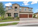 Beautiful two-story home with stone accents, a three-car garage, and well-maintained landscaping at 12795 Fisherville Way, Riverview, FL 33579