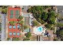 Aerial view showcases community amenities: tennis, basketball, pickleball courts, and a sparkling pool at 12904 Teakwood Ln, Hudson, FL 34667