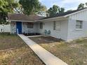 Inviting home exterior featuring a cozy front yard, blue door, and well-manicured landscaping at 1407 College Park Ln, Tampa, FL 33612