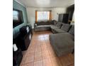 Cozy living room featuring a large sectional couch, TV, and tile flooring at 1407 College Park Ln, Tampa, FL 33612