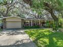 Charming single-story home featuring a manicured lawn, stone accents, and a well-maintained exterior at 14350 11Th St, Dade City, FL 33523
