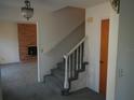 Entryway with a staircase, a modern chandelier and an orange door leading to other rooms in the house at 14614 Lake Magdalene Cir, Tampa, FL 33613