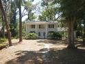 Charming two-story home featuring a classic facade, symmetrical design and mature trees surrounding the property at 14614 Lake Magdalene Cir, Tampa, FL 33613