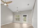 Bright living room featuring vaulted ceilings, modern ceiling fans, wood-look floors, and a sliding glass door at 1640 Lullwater Ln, Lutz, FL 33549
