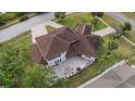 An aerial view of a home showing a large brick patio with outdoor furniture and lush green landscaping at 1915 Belleair Rd, Clearwater, FL 33764