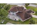 An aerial view of a home showing a large brick patio with outdoor furniture and lush green landscaping at 1915 Belleair Rd, Clearwater, FL 33764