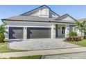 Wide driveway leading to a three-car garage, complemented by a manicured lawn and landscaping at 324 3Rd N Ave, Safety Harbor, FL 34695