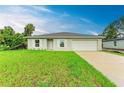 Well-maintained single-story home featuring a lush green lawn and a two-car garage at 3879 E Price Blvd, North Port, FL 34288