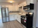Bright kitchen with white cabinets, stainless steel appliances, and stylish gray backsplash at 4316 70Th N Ave, Pinellas Park, FL 33781