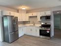 Modern kitchen featuring white cabinets, stainless steel appliances, and beautiful gray backsplash at 4316 70Th N Ave, Pinellas Park, FL 33781