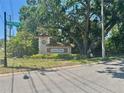 The entryway to Grassy Pointe shows beautiful landscaping around a large sign at 476 Denise St, Tarpon Springs, FL 34689