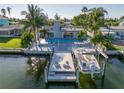 Waterfront home featuring a private dock, boat lift, swimming pool, and outdoor lounge area for relaxed coastal living at 533 Lillian Dr, Madeira Beach, FL 33708