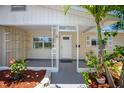 Inviting covered front porch featuring white support beams, charming planters, and the house number above the door at 568 La Plaza S Ave, St Petersburg, FL 33707