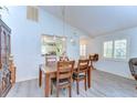 Open dining room featuring a wooden table, modern lighting, and laminate flooring at 5906 Greenbriar Ct, Zephyrhills, FL 33542