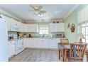 Cozy kitchen featuring white cabinets, laminate countertops, and a window with natural light at 5906 Greenbriar Ct, Zephyrhills, FL 33542