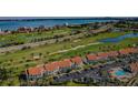 Expansive aerial showcasing golf course condos with a red-tiled roof and a swimming pool in a waterfront community at 6191 Bahia Del Mar Blvd # 103, St Petersburg, FL 33715