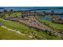 Breathtaking aerial view of condos with a red-tiled roof nestled along a pristine waterfront golf community at 6191 Bahia Del Mar Blvd # 103, St Petersburg, FL 33715