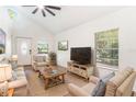Bright living room boasts vaulted ceilings, comfortable seating, and a ceiling fan at 7309 N Huntley Ave, Tampa, FL 33604