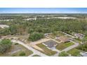 Wide aerial view of a property surrounded by lush greenery and neighboring houses and roadways at 7372 Madrid Rd, Weeki Wachee, FL 34613